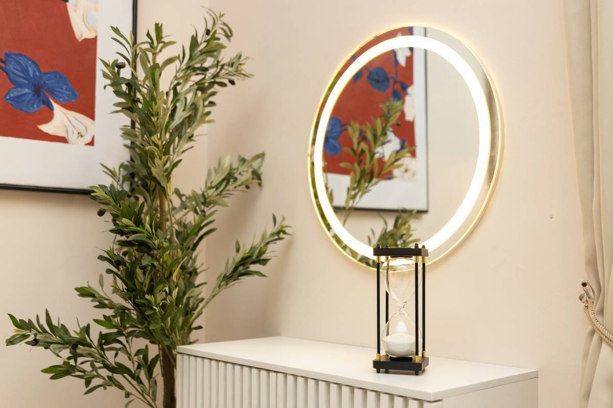 A stylish vanity mirror with lights mounted on a modern makeup table, showing even illumination across the face